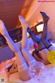 A couple of women laying on top of a bed with balloons.