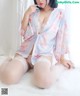 a woman sitting on top of a bed wearing stockings and a robe