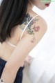 A woman with a tattoo of flowers on her arm.